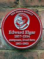 Red plaque erected in 2013 by The Elgar Society at 2 Cathedral Precincts, Worcester (© Spudgun67, CC BY-SA 4.0)